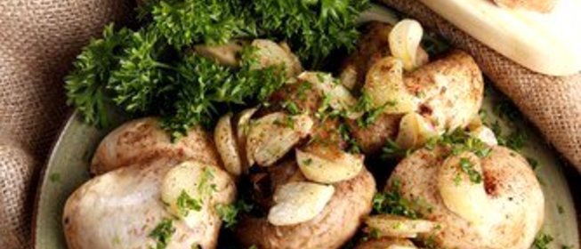 Шляпки грибов на гриле с чесноком и зеленью