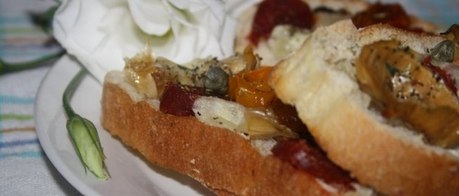 Кростини с печеными артишоками, чоризо, каперсами и молодым овечьим сыром