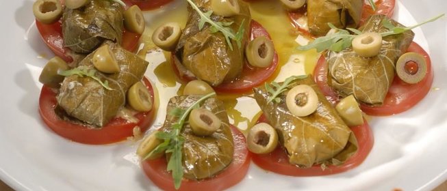 Козий сыр в виноградных листьях с томатами и оливками